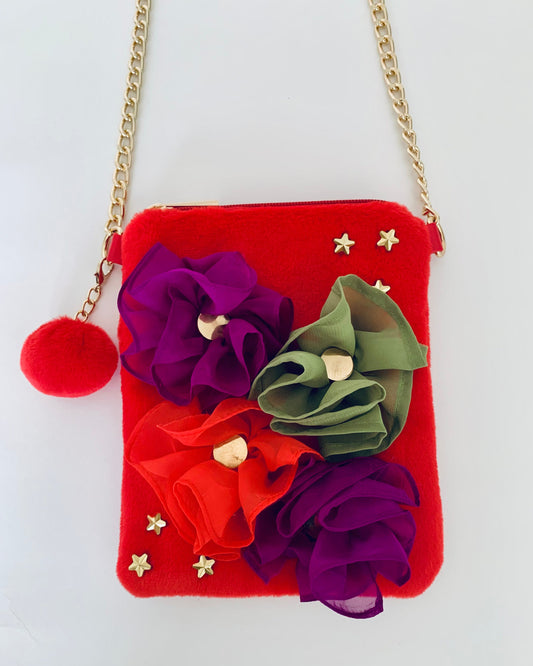 Red handbag with floral decorations and a gold chain on a white background