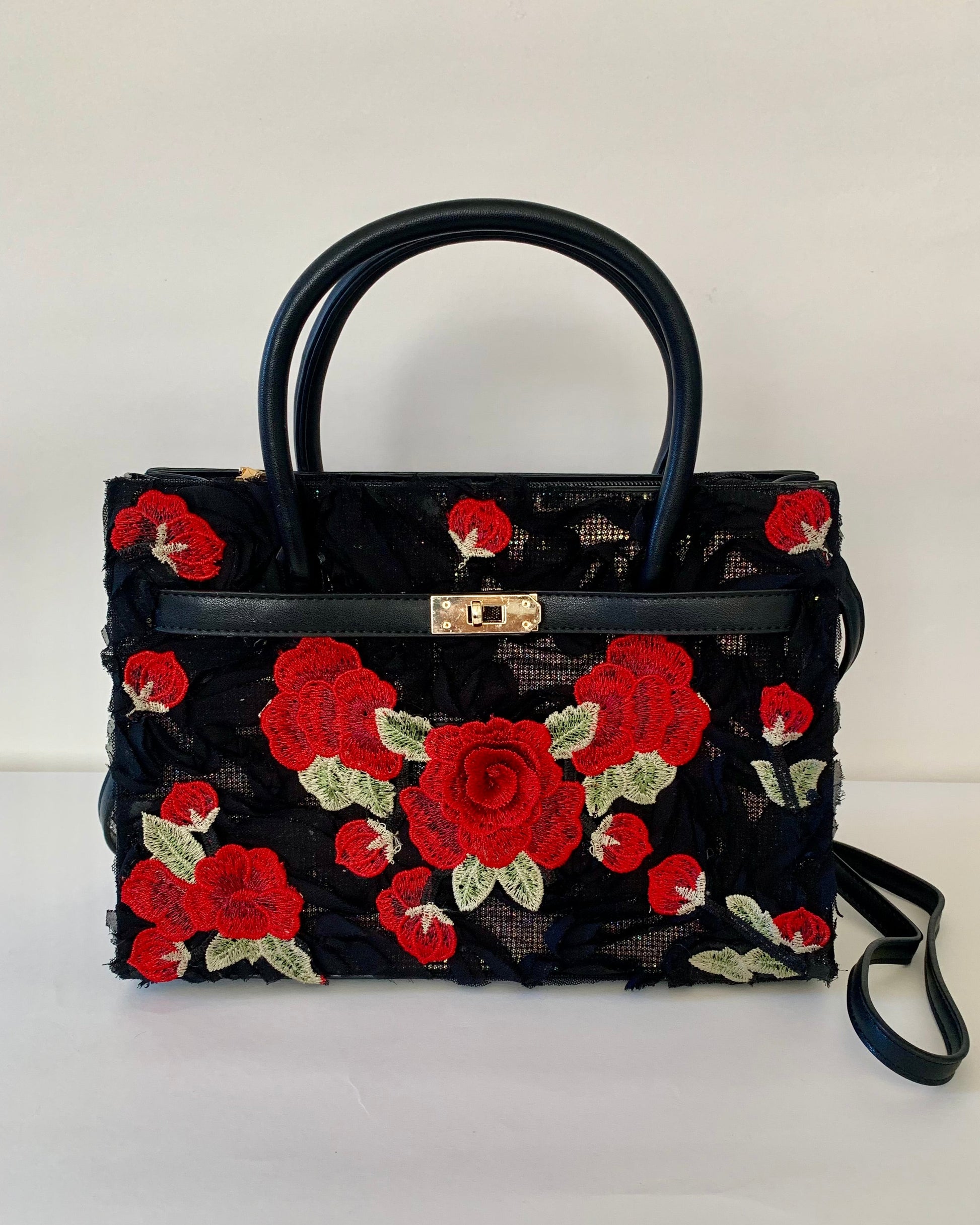 Black handbag with red floral embroidery on a white background